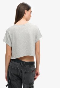 Grijze gegoten T-shirt met korte mouwen, zachte textuur en een brede halslijn, gecombineerd met donkergrijze high-waisted cargobroek met zakken.