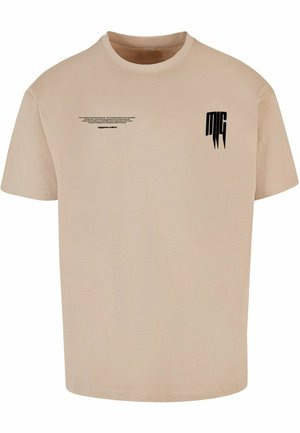 Beige t-paita, jossa on lyhyet hihat, pyöreä kaula-aukko ja musta painettu teksti edessä sekä logo vasemmassa rinnassa.