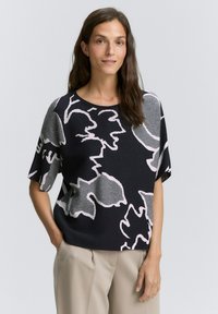 Czarny sweter krótki rękaw z jasnoróżowym abstrakcyjnym wzorem kwiatowym. Miękki dzianinowy materiał, luźny krój i okrągły dekolt.