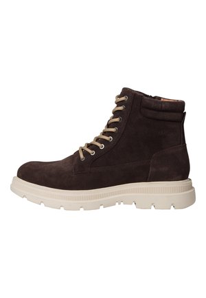 Bottine en suède marron avec une semelle en caoutchouc beige, dotée d'œillets en métal et de lacets beiges, à bout rond et avec un col rembourré pour le soutien.