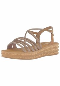 Riemchen-Wedge-Sandalen mit einem beigen, strukturierten Obermaterial, das mehrere gekreuzte Riemen und eine geschichtete, geflochtene Sohle für Stabilität aufweist.