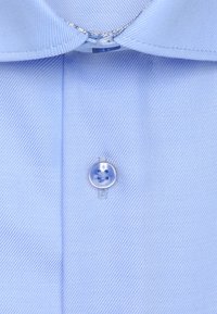Chemise bleu clair en tissu lisse avec un motif à rayures verticales, un col pointu et un bouton en plastique transparent au centre.