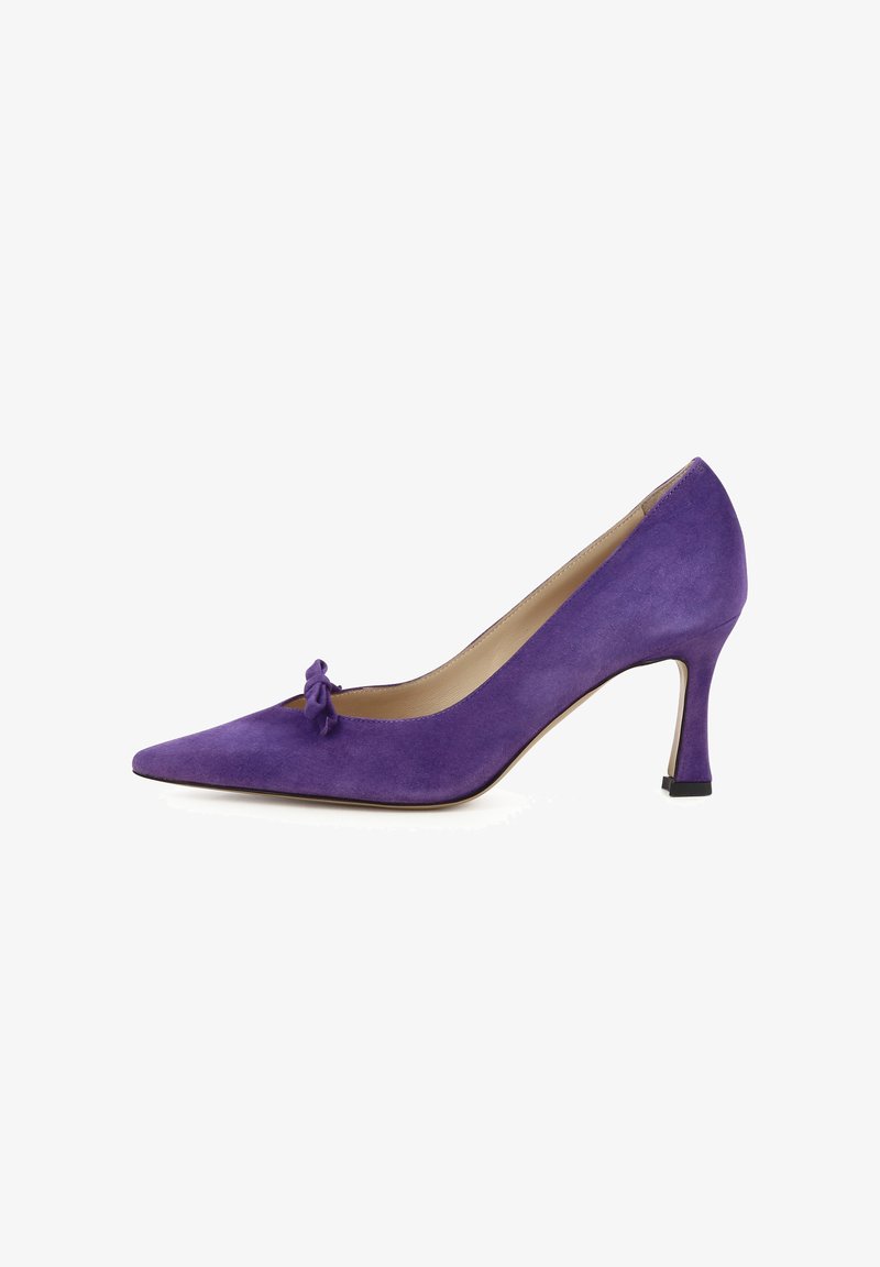 Scarpa con tacco alto in suede viola, con punta affusolata e piccolo fiocco decorativo nella parte anteriore. Il tacco è sottile e alto circa 7,5 cm.