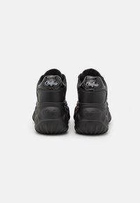 Paire de baskets Buffalo noires à semelles épaisses vues de dos, montrant le logo de la marque sur les talons et les parties supérieures.