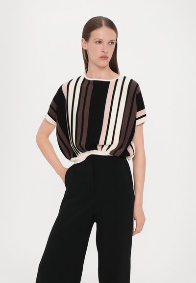 Striped short-sleeve blouse in shades of black, pink, and white, featuring a rounded neckline and relaxed fit, paired with black wide-leg pants.
