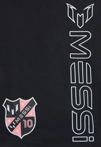 Czarna koszulka sportowa z białymi i różowymi nadrukami, w tym logo tarczy z napisem "MESSI" i "10". Gładka faktura, krój z okrągłym dekoltem.