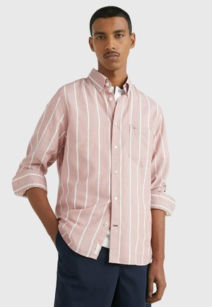 Camicia button-up rosa chiaro con strisce verticali bianche, taschino sul petto, maniche arrotolate e orlo curvo. Tessuto in cotone.