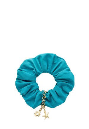 Turkusowa gumka do włosów z dołączonym złotym łańcuszkiem ozdobionym zawieszkami w kształcie słońca i rozgwiazdy na białym tle.