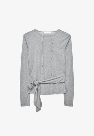 Jasnoszary, długi sweter na guziki z przodu i wiązaniem bocznym, wykonany z miękkiego, lekkiego materiału.