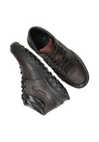 Bruine leren sneakers met textuur, donkere veters en rubberen zolen. Kenmerkende ontwerpelementen zijn onder andere geïntegreerde oogjes en hielaccenten.