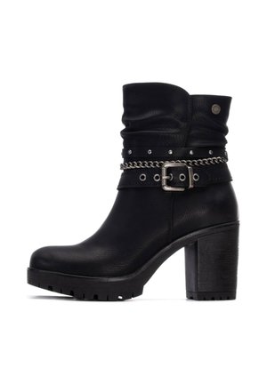 Botín de cuero negro con parte superior arrugada, tacón alto y grueso, acento de cinturón con tachuelas, detalle de cadena metálica y suela de goma texturizada.