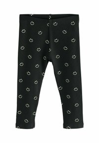 Leggings negre cu striații, având un model repetat cu fețe zâmbitoare albe. Talie elastică și design până la gleznă. Textură moale.