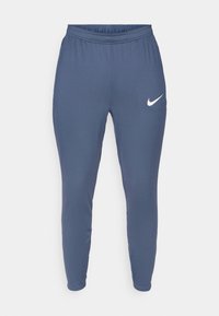 Nike sweatpants i mørkeblå, som har elastisk midjebånd, smale ben og en hvit logo på venstre lår. Myk, glatt tekstur.