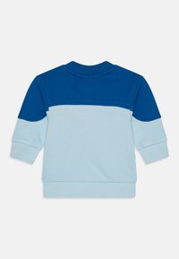 Felpa con una parte superiore blu e una parte inferiore azzurra, dotata di polsini e colletto a coste. Materiale in cotone morbido con una superficie liscia.