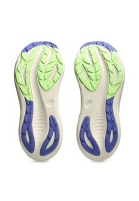 Shoe soles featuring a light cream base with purple and green rubber traction patterns, curved shapes, and textured grooves throughout.