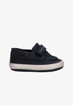 Scarpa barca per bambini blu navy con suola bianca e cinturino in Velcro con la scritta "TOMMY" sul lato.