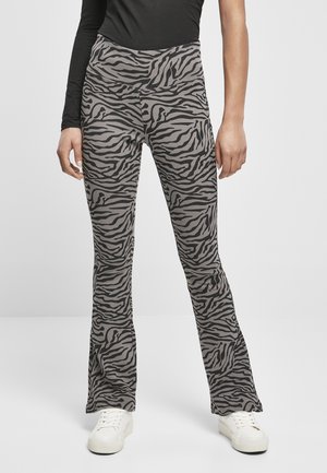 Bredde bukser i en lysegrå stof med et sort zebrastribemønster. Designet med høj talje og parret med hvide sneakers.