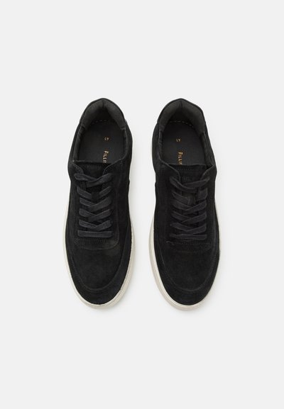 Black suede sneakers with flat laces, rounded toe, and a white rubber sole. The interior features a cushioned lining for comfort.
