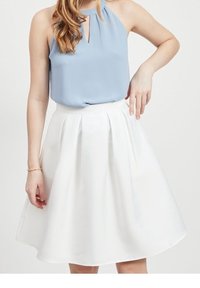 Světle modrý halter top s výstřihem ve tvaru klíčové díry, doplněný bílou plisovanou sukní ve tvaru A. Hladká látka, délka po kolena, jemný lesk.