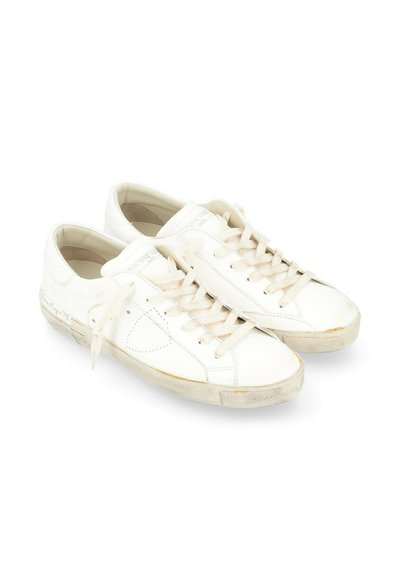 Sneaker bianche in pelle con design a punta bassa, dotate di lacci piatti, suola leggermente usurata e dettagli di cucitura minimalisti.