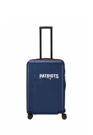 Blauer Hartschalenkoffer mit verlängertem schwarzem Griff, vier Rädern und weißem "Patriots" Text mit Logo vorne in der Mitte.