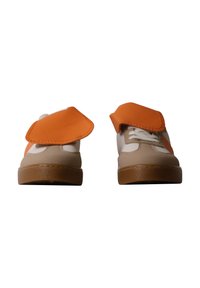 Paire de chaussures beige et blanches avec semelles marron et grands rabats orange ouverts couvrant les lacets.