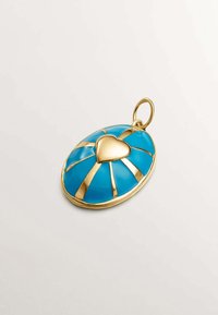 Colgante de oro con un fondo de esmalte turquesa, acentuado por un corazón y líneas doradas que irradian. Forma redonda, textura suave.