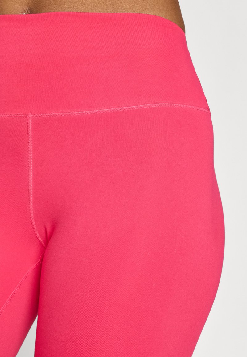 Hochtaillierte, eng anliegende Leggings aus leuchtend pinkem Stoff mit glatter Textur und minimalen Nähten.