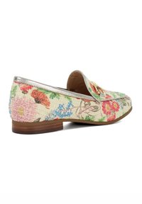 Mocassins floraux avec un dessus tissé texturé en beige, ornés de fleurs vibrantes roses, bleues et rouges. Détails argentés sur le col.