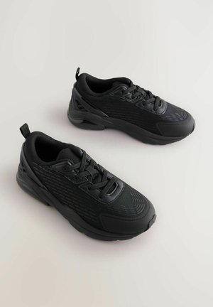 Svarta sportskor med strukturerad ovandel, vadderad tunga och kontrasterande glänsande detaljer. Gummisula med rundad tå och snörningssystem.