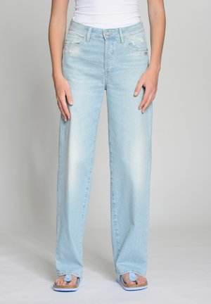 Light blue wide-leg jeans with a faded finish, featuring distressed accents, and traditional pockets. Paired with blue flip-flops.