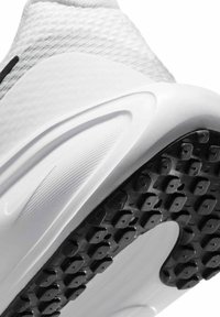 Zapatilla deportiva blanca con parte superior texturizada y suela de goma negra, que presenta nudos de tracción distintivos y un diseño aerodinámico.