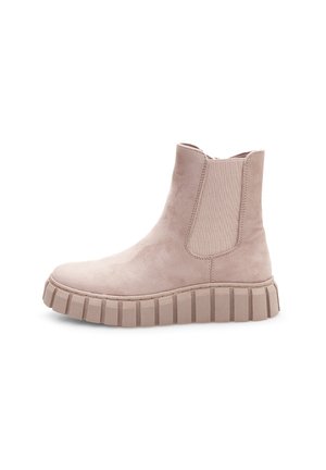 Bottines en daim beige clair avec des panneaux élastiques sur les côtés et une semelle crantée épaisse. Présente un bout arrondi et une texture lisse sur l'ensemble.