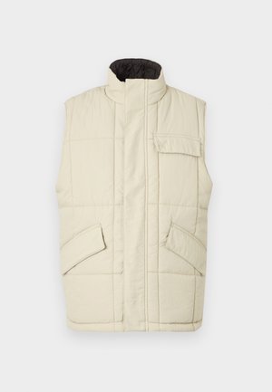 Lichtbeige mouwloze puffer vest met een hoge kraag, een ritssluiting aan de voorkant, twee zijzakken en een klein borstzakje. Gevoerde, gestructureerde stof.