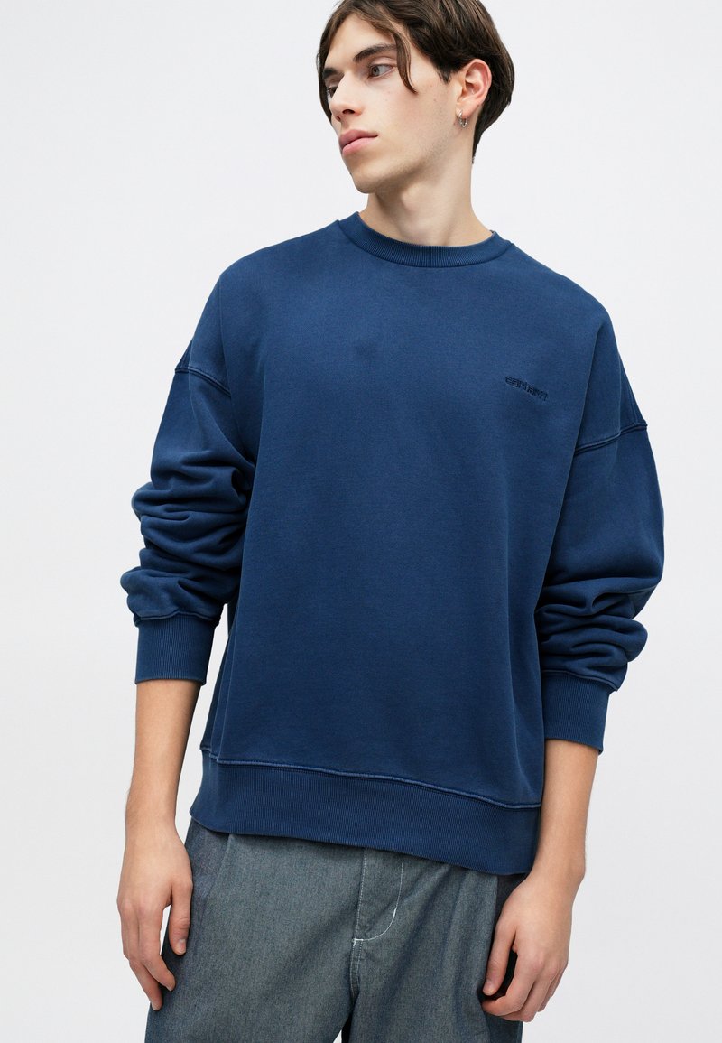 Marineblaue Sweatshirt mit lockerer Passform, rundem Halsausschnitt, gerippten Bündchen und Saum. Mit einem dezenten Logo auf der Brust und weichem Material.