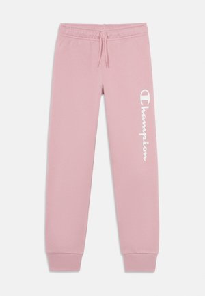 Ružové tepláky s elastickým pásom a šnúrkou, s bielym vertikálnym logom "Champion" na ľavej nohe a lemovanými členkami.
