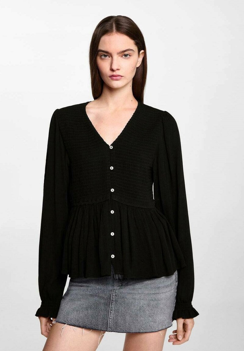Black button-up blouse with a V-neck, long sleeves, and smocked texture at the bodice. Features a peplum hem and white buttons.