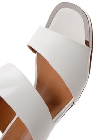 Sandale ouverte blanche à bout carré dotée de deux larges brides, en cuir lisse, avec un accent métallique sur le talon.