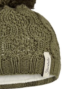 Olive green knitted wool hat with cable patterns, pom-pom on top, and white fabric tag reading "Sterntaler" on the side.