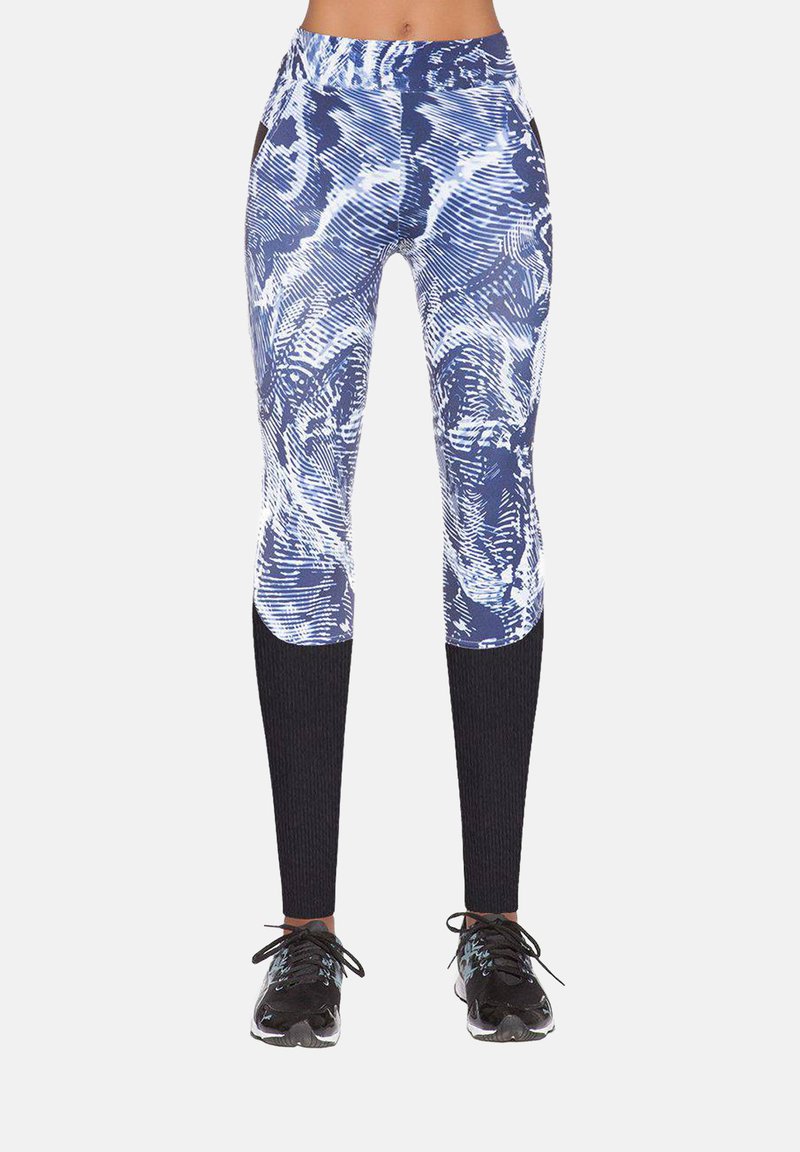 Legginsy w niebiesko-biały wzór z wysokim stanem, z teksturowanym czarnym prążkowanym panelem na dolnych partiach nóg. Czarny sportowy obuwie dopełnia stylizację.