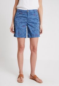 Shorts bleus avec un motif floral violet et vert. Fabriqués en matière légère, dotés d'une fermeture à boutons à l'avant et de poches latérales.