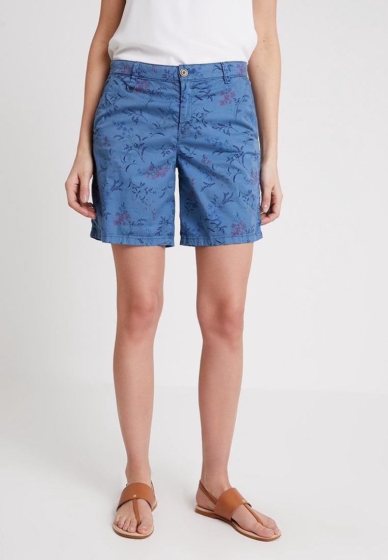 Shorts bleus avec un motif floral violet et vert. Fabriqués en matière légère, dotés d'une fermeture à boutons à l'avant et de poches latérales.