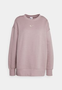 Světle fialová mikina vyrobená z měkkého fleece materiálu, s kulatým výstřihem, spadlými rameny a malým zlatým logem Nike na hrudi.