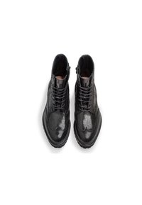 Botas de tobillo de cuero negro con un acabado texturizado, diseño de cordones y cremallera lateral, que presentan una punta redondeada y una suela de goma con tracción.