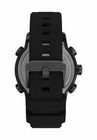 Timex óra fekete szilikon szíjjal, ezüst fém csattal és több gombbal. Kerek tok, látható rozsdamentes acél hátlappal.
