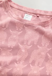 Roze stof met lichtroze patronen van Hoogland-runderen en een label bij de halslijn met de tekst "VOLGENDE keer naar" op zachte katoen.