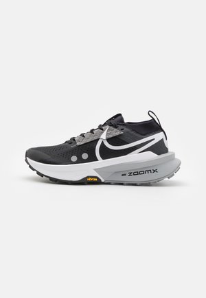 Baskets de course noires avec une tige en mesh, des accents réfléchissants et une semelle intermédiaire blanche. Dotées d'une semelle extérieure en Vibram et de la technologie d'amorti ZoomX.