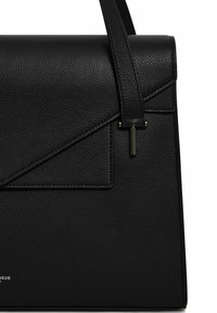 Borsa in pelle nera con un design strutturato, caratterizzata da una superficie testurizzata, un cappuccio triangolare e una tracolla sottile con accessori metallici.