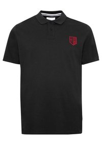 Černé polo tričko s krátkým rukávem, se dvěma knoflíky a červeným štítovým emblémem na levé části hrudi, který obsahuje hvězdy a pruhy.