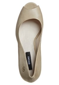 Chaussure plate en daim beige à bout ouvert avec étiquette noire "BRONX" sur la semelle intérieure rembourrée, vue de dessus sur fond blanc.